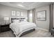 Calm bedroom featuring a tray ceiling, a large window with neutral curtains, and a well-made bed with decorative pillows at 197 Glen Hollow Dr, Raleigh, NC 27604
