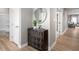 Bright hallway with light-wood floors, stylish dark accent cabinet, and views of the bathroom and living area at 197 Glen Hollow Dr, Raleigh, NC 27604