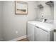 Bright laundry room with side-by-side washer and dryer, and storage shelf at 197 Glen Hollow Dr, Raleigh, NC 27604