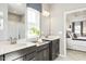 Bright bathroom with dual sinks, white countertops, shower and doorway to the main bedroom at 198 Glen Hollow Dr, Raleigh, NC 27604
