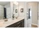 A well-lit bathroom with a double sink vanity and a partial view into the bedroom and attached bath at 198 Glen Hollow Dr, Raleigh, NC 27604