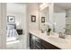 A bathroom featuring a double sink vanity with white countertops and a glimpse into a bedroom through an open door at 198 Glen Hollow Dr, Raleigh, NC 27604