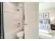 Bright white bathroom with a tub shower and toilet visible through a partially opened white door to the bedroom at 198 Glen Hollow Dr, Raleigh, NC 27604