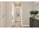 Open hallway, beige walls, decorated with dark wood cabinet with a vase and 2 framed pictures on the wall at 198 Glen Hollow Dr, Raleigh, NC 27604