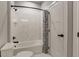 Bright bathroom featuring a shower-tub combo with marble-style tiling and black hardware at 199 Glen Hollow Dr, Raleigh, NC 27604
