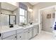 Bathroom with dual sinks, gray cabinetry, and a window for natural light at 199 Glen Hollow Dr, Raleigh, NC 27604