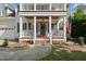 Inviting front porch showcasing decorative columns, an American flag, and freshly planted flowers at 2027 River Grove Ln, Knightdale, NC 27545
