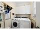Bright laundry room with white cabinets and modern Samsung washer and Whirlpool dryer for efficient stain removal at 2027 River Grove Ln, Knightdale, NC 27545
