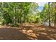 View of the spacious backyard surrounded by mature trees and a storage shed at 205 Northfield Dr, Raleigh, NC 27609