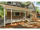 Charming covered porch with painted columns, brick accents, and serene outdoor space at 205 Northfield Dr, Raleigh, NC 27609