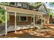 Charming covered porch with painted columns, brick accents, and serene outdoor space at 205 Northfield Dr, Raleigh, NC 27609