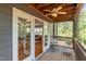 View of the cozy screened-in porch with wooded views at 205 Northfield Dr, Raleigh, NC 27609