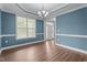Bright dining room featuring hardwood floors, a modern chandelier, and abundant natural light from a large window at 2057 Big Falls Dr, Wendell, NC 27591