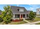 Charming home exterior with a red front door, manicured landscaping, and inviting front porch at 2057 Big Falls Dr, Wendell, NC 27591