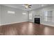 Bright living room with a fireplace, ceiling fan and three large windows letting in natural light at 2057 Big Falls Dr, Wendell, NC 27591
