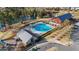 Aerial view of a community pool with lush landscaping, a lake, and a recreation center for outdoor enjoyment at 2057 Big Falls Dr, Wendell, NC 27591