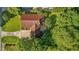 Aerial view of home featuring a red roof, backyard patio, and lush surrounding trees at 2257 Delaney Dr, Burlington, NC 27215
