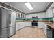 Kitchen with white cabinets, stainless steel appliances, and decorative wallpaper above the cabinets at 2257 Delaney Dr, Burlington, NC 27215