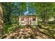 Well-maintained shed with red and white trim and a brick pad, surrounded by mature trees at 2257 Delaney Dr, Burlington, NC 27215