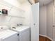 Bright laundry room with washer, dryer, and convenient shelving for storage at 23 Joci Ct, Durham, NC 27704