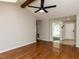 Bright living room with vaulted ceilings, wooden beam, fan, and gleaming hardwood floors at 23 Joci Ct, Durham, NC 27704