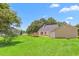 Well-maintained backyard showcasing a spacious lawn, deck, mature tree coverage and a storage shed at 232 S Marshall St, Graham, NC 27253