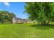 Large backyard featuring lush green grass, a deck, and mature shade trees providing ample shade at 232 S Marshall St, Graham, NC 27253