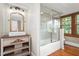 Bathroom featuring a shower with glass doors, a vanity, and decorative mirror at 232 S Marshall St, Graham, NC 27253