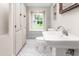 Bathroom featuring a pedestal sink, built-in cabinets, and patterned tile flooring at 232 S Marshall St, Graham, NC 27253