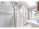 Bathroom with subway tile shower, glass doors, a skylight, and decorative wall tiles at 232 S Marshall St, Graham, NC 27253