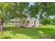 View of a charming home with a well-manicured lawn and deck area from under the shade of a tree at 232 S Marshall St, Graham, NC 27253