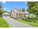Charming home with detached garage and a well-maintained gravel driveway surrounded by green lawns at 232 S Marshall St, Graham, NC 27253