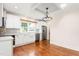 Bright kitchen features white cabinets, stainless steel appliances, hardwood floors and large window at 232 S Marshall St, Graham, NC 27253