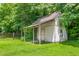 Vintage backyard storage shed, featuring a rustic tin roof and weathered white paint with a trellis at 232 S Marshall St, Graham, NC 27253