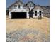 Under-construction home with Tyvek wrap, showing framing and garage opening at 2404 Flemingstone Ln # 51, Raleigh, NC 27610