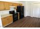 This kitchen offers wood cabinets, black appliances, and wood flooring, maximizing the space at 2662 Walas Ct, Creedmoor, NC 27522