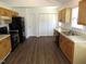 Functional kitchen with wooden cabinets, black appliances, and a large pantry with hardwood flooring at 2662 Walas Ct, Creedmoor, NC 27522