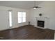 Well-lit living room featuring a fireplace, a ceiling fan, white walls, and dark hardwood floors at 2662 Walas Ct, Creedmoor, NC 27522