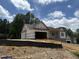 New construction home with a brick foundation and attached two-car garage, nearing completion at 299 Little Lady Trail, Zebulon, NC 27597