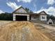 New construction home with a two-car garage and front-facing porch awaits its finishing touches at 299 Little Lady Trail, Zebulon, NC 27597