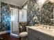 Stylish bathroom with glass shower and vanity with blue floral wallpaper at 300 W Roanoke Park Dr, Raleigh, NC 27608