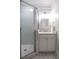 Bright bathroom featuring a shower with patterned tile and a vanity with cabinet storage at 300 W Roanoke Park Dr, Raleigh, NC 27608