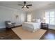 A cozy bedroom with hardwood floors, neutral rug, white bedding, and a comfortable sitting chair at 300 W Roanoke Park Dr, Raleigh, NC 27608
