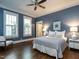 A bedroom with wood floors, two bright windows with shutters, and a blue accent wall at 300 W Roanoke Park Dr, Raleigh, NC 27608