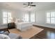 A bright bedroom features a ceiling fan, three windows with white shutters, and hardwood floors at 300 W Roanoke Park Dr, Raleigh, NC 27608