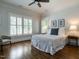 This cozy bedroom features wood floors, a ceiling fan, and neutral walls with white shutters at 300 W Roanoke Park Dr, Raleigh, NC 27608