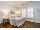 Bedroom with hardwood floors, white trim, white plantation shutters, and white bedding at 300 W Roanoke Park Dr, Raleigh, NC 27608