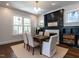Elegant dining room with modern lighting, fireplace, and a view of the backyard at 300 W Roanoke Park Dr, Raleigh, NC 27608