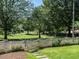 Landscaped front yard featuring a white picket fence and views of the neighborhood park at 300 W Roanoke Park Dr, Raleigh, NC 27608