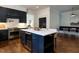 Open kitchen with island seating, stainless appliances, navy cabinets, and eat-in dining at 300 W Roanoke Park Dr, Raleigh, NC 27608